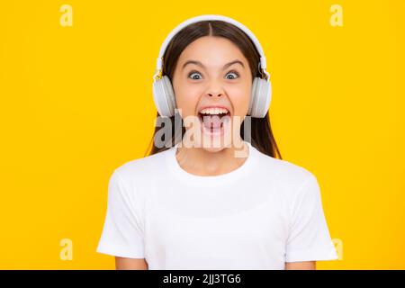 Bambini entusiasti che ascoltano musica con le cuffie. Ragazza che ascolta i brani tramite auricolari wireless. Accessorio per dispositivo auricolare. Ragazza adolescente alla moda Foto Stock