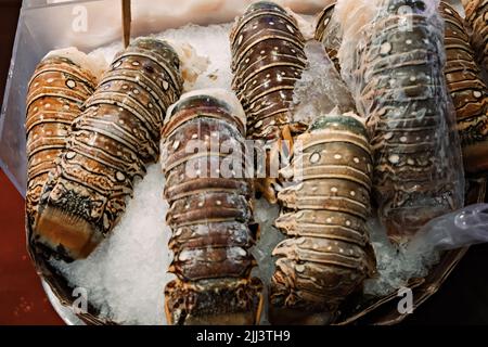 Code di aragosta su ghiaccio in un mercato di pesce fresco a Seattle Foto Stock