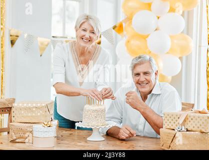 Un altro anno, un'altra candela sulla torta. Una coppia anziana felice festeggia un compleanno nel paese. Foto Stock