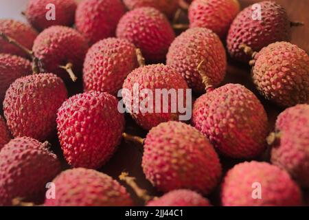 Frutta Lichia - sono piccoli frutti, con pelle rossastra e ruvidità. La polpa è bianca e succosa, dal sapore dolce e leggermente acido. Foto Stock