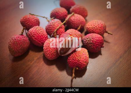 Frutta Lichia - sono piccoli frutti, con pelle rossastra e ruvidità. La polpa è bianca e succosa, dal sapore dolce e leggermente acido. Foto Stock