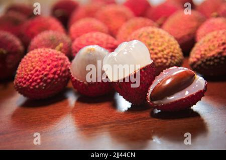 Frutta Lichia - sono piccoli frutti, con pelle rossastra e ruvidità. La polpa è bianca e succosa, dal sapore dolce e leggermente acido. Foto Stock