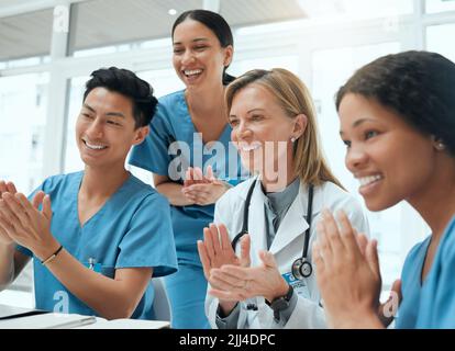 Ogni risultato merita un applauso: Un gruppo di medici si aggrappa in una riunione sul lavoro. Foto Stock