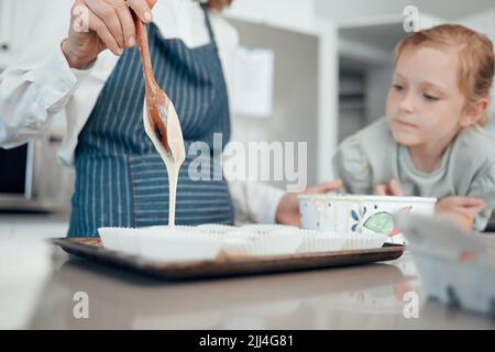 E proprio come la magia, si trasformeranno in una delizia. Primo piano di una nonna che cuoce con la nipote a casa. Foto Stock