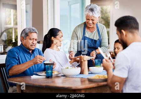 Mi auguro che i ragazzi vi godano. Una famiglia felice che pranzano insieme a casa. Foto Stock
