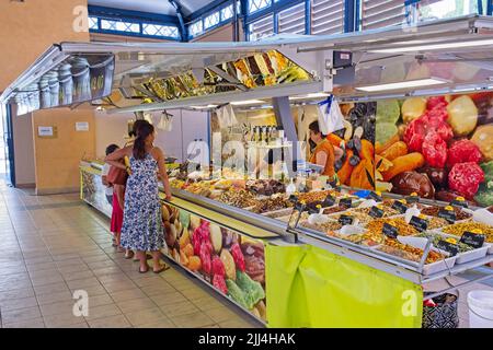 Limoux Aude Francia 07.22.22 mercato interno stalla vendita di frutta secca e noci. Giovani donne in abiti estivi. Immagini dai colori vivaci della produzione Foto Stock