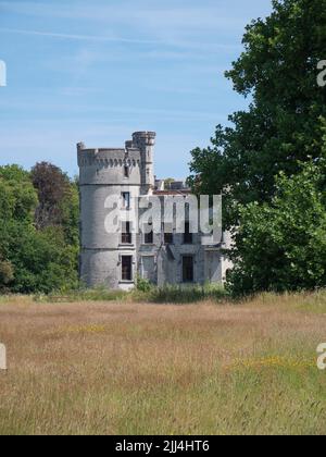 Meise, Belgio, 17 luglio 2022, la torre del castello di Bouchout dal 12th secolo nel mezzo di un giardino paesaggistico con piante esotiche foto Foto Stock