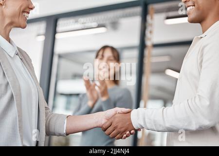 Theres un caricamento medio del team. Due uomini d'affari irriconoscibili che scuotono le mani in un ufficio al lavoro. Foto Stock