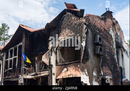 Casa con bandiera Ucraina distrutta dall'esercito russo nella periferia di Kyiv (Irpin), guerra della russia contro l'Ucraina. Foto Stock