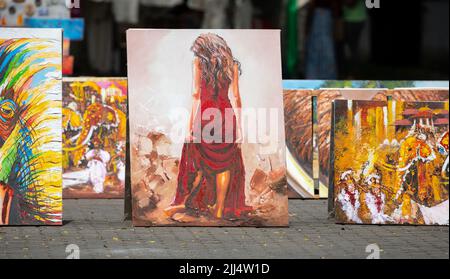 Galle, Sri Lanka - 06 11 2022: Mostra di dipinti ad olio su Galle Fort Street. Splendida pittura di una ragazza con una crema rossa al centro. Foto Stock