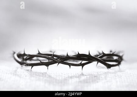 Corona di spine che simboleggia il sacrificio, la sofferenza e la risurrezione di Gesù Cristo sulla croce e sullo sfondo della luce pasquale Foto Stock