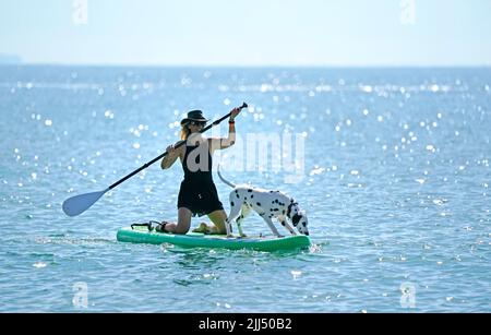 Marina White da Bournemouth con il suo cane, Coco praticando prima del Dog Masters 2022 UK Dog Surfing Championships alla spiaggia Branksome Dene Chine a Poole, Dorset. Data foto: Sabato 23 luglio 2022. Foto Stock