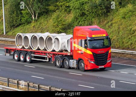 John Miller Limited 2022 IVECO STRALIS 12882 cc autocarro con pianale HGV che trasporta sezioni di drenaggio in calcestruzzo, viaggiando sull'autostrada M6 nel Regno Unito Foto Stock