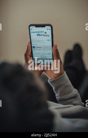 Primo piano delle mani che tengono il nuovo nome di Meta facebook sul telefono cellulare con il nuovo logo facebook Foto Stock