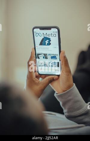 Primo piano delle mani che tengono il nuovo nome di Meta facebook sul telefono cellulare con il nuovo logo facebook Foto Stock