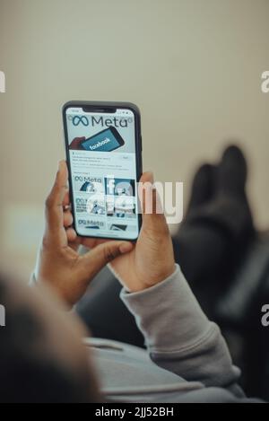 Primo piano delle mani che tengono il nuovo nome di Meta facebook sul telefono cellulare con il nuovo logo facebook Foto Stock