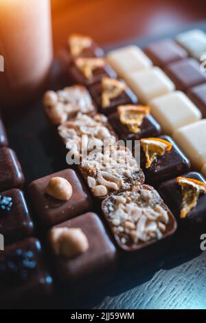 set di deliziose caramelle al cioccolato fatte a mano con caffè da portare in una tazza di carta Foto Stock