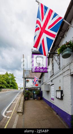 The George, un pub sulla strada con un cartello George Orwell 1984 e la bandiera Union Jack a Fordingbridge, un piccolo villaggio nella New Forest, Hampshire Foto Stock