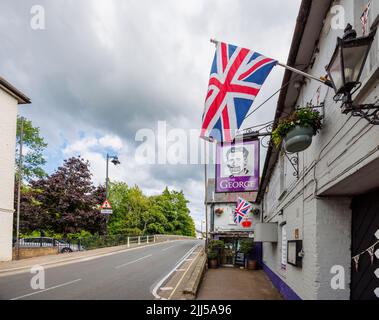 The George, un pub sulla strada con un cartello George Orwell 1984 e la bandiera Union Jack a Fordingbridge, un piccolo villaggio nella New Forest, Hampshire Foto Stock