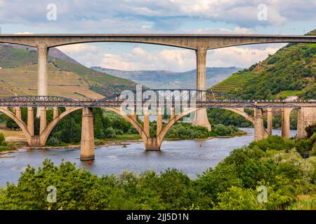 Un ponte in acciaio per pedoni e due ponti per il traffico attraversano il fiume Douro a peso da Regua, Portogallo Foto Stock
