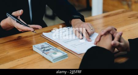 la gente firma il contratto per prendere in prestito i soldi dall'investitore per investire al proprio business. prestito ipotecario concetto di finanziamento. Foto Stock