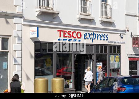 Gli acquirenti entrano in un Tesco Express su Bridge Street a Stratford upon Avon, Inghilterra. Concetto - costo della vita, shopping alimentare, aumento dell'inflazione Foto Stock