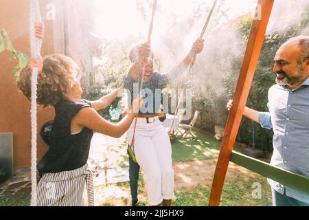Donna felice godendo con la famiglia nel cortile Foto Stock