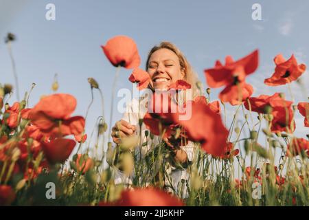 Donna felice con gli occhi chiusi in campo papavero Foto Stock