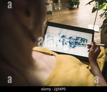 Ingegnere maturo che disegna su un tablet grafico in ufficio Foto Stock