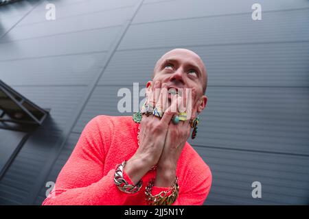 Uomo maturo che indossa anelli gesturing davanti al muro Foto Stock