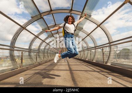 Ragazza felice che salta sul ponte alla stazione di Elbbrucken, Germania Foto Stock