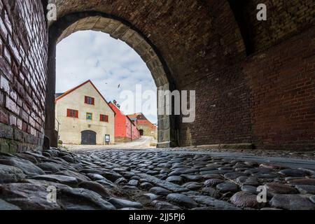 Svezia, Halland, Varberg, sentiero di Cobblestone e uscita ad arco nella fortezza di Varberg Foto Stock