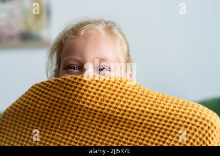 Ragazza nascondendo faccia sotto coperta a casa Foto Stock