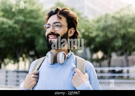 Uomo sorridente con cuffie wireless Foto Stock
