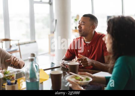 I colleghi di lavoro sono felici di fare degli spuntini alla reception Foto Stock