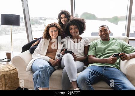 Amici felici seduti sul divano insieme Foto Stock