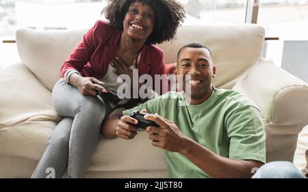 Felice giovane donna che gioca video gioco con l'uomo Foto Stock