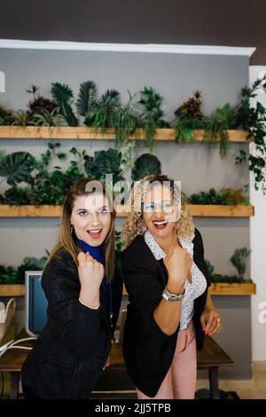 Sorridenti donne d'affari multirazziali che stringono pugni in ufficio Foto Stock