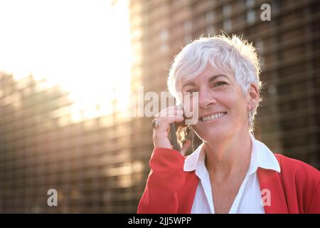 Sorridente imprenditrice parlando al telefono cellulare Foto Stock