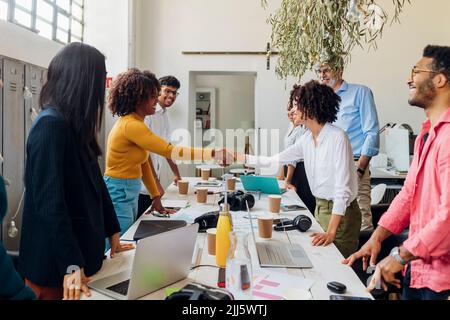 Le donne d'affari sorridenti scuotono le mani in una riunione d'ufficio Foto Stock