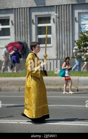 Giovane uomo ortodosso monaco portando candela di chiesa sulla strada durante la processione croce. Luglio 28, 2019. Kiev, Ucraina Foto Stock