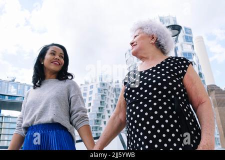 Figlia e madre che tengono le mani camminare insieme Foto Stock
