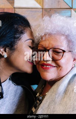 Figlia e madre con gli occhi chiusi abbracciandosi Foto Stock