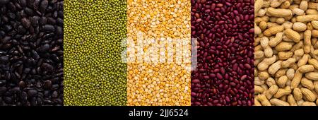 Diversi tipi di legumi banner, arachidi e fagioli mung, piselli gialli e fagioli rossi e neri, vista dall'alto Foto Stock