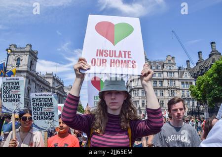 Londra, Inghilterra, Regno Unito. 23rd luglio 2022. Un manifestante tiene in piazza del Parlamento un cartello con la frase "'insulate our homes'". I manifestanti di Just Stop Oil, la ribellione dell’estinzione, isolano la Gran Bretagna e altri gruppi che hanno organizzato una marcia attraverso il centro di Londra chiedendo al governo di porre fine ai combustibili fossili, tassare i grandi inquinatori e i miliardari, fornire isolamento per tutte le case e agire sul clima e sui costi delle crisi viventi. (Credit Image: © Vuk Valcic/ZUMA Press Wire) Foto Stock