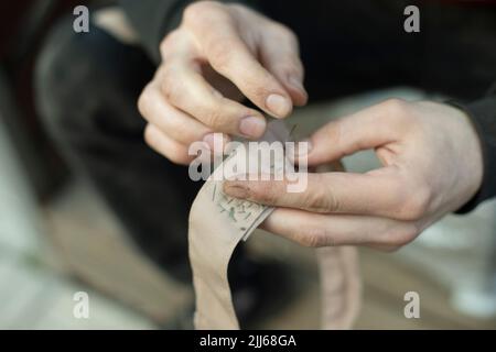 Nastro per cucire. Colletto cucito in esercito. Lavoro di tessitore. Riparare gli abiti con le mani. Foto Stock