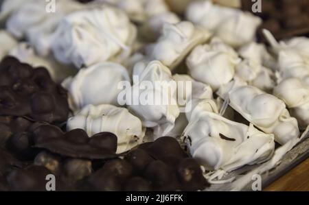 Particolare di noci ricoperse di cioccolato bianco e nero Foto Stock