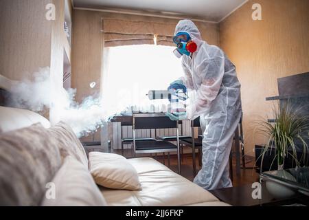 disinfezione della stanza contro i virus. Uomo in quarantena vestiti disinfezione stanza. Foto Stock