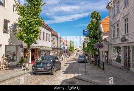 BMW i3 berlina elettrica guida sopra la strada acciottolata norvegese dello shopping nella città di Stavanger, Norvegia Foto Stock