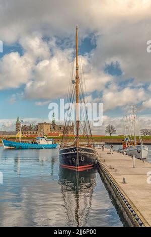 Un colpo verticale di barche al porto della città di Helsingor con il castello di Kronborg all'orizzonte, la Danimarca Foto Stock
